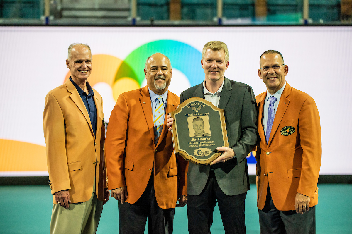 group photo at Jim Courier Orange Bowl Hall of Fame Presentation with plaque