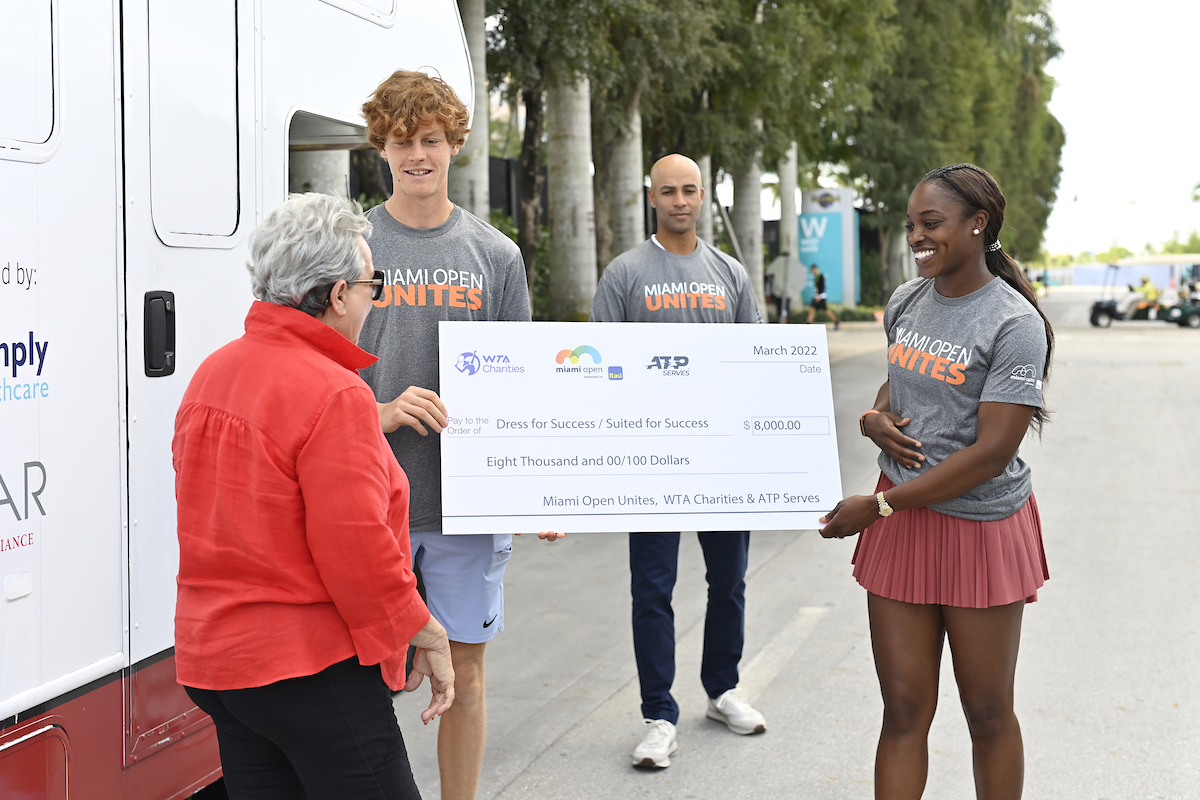 Jannik Sinner and Sloane Stephens present a check to Suited for Success during Miami Open