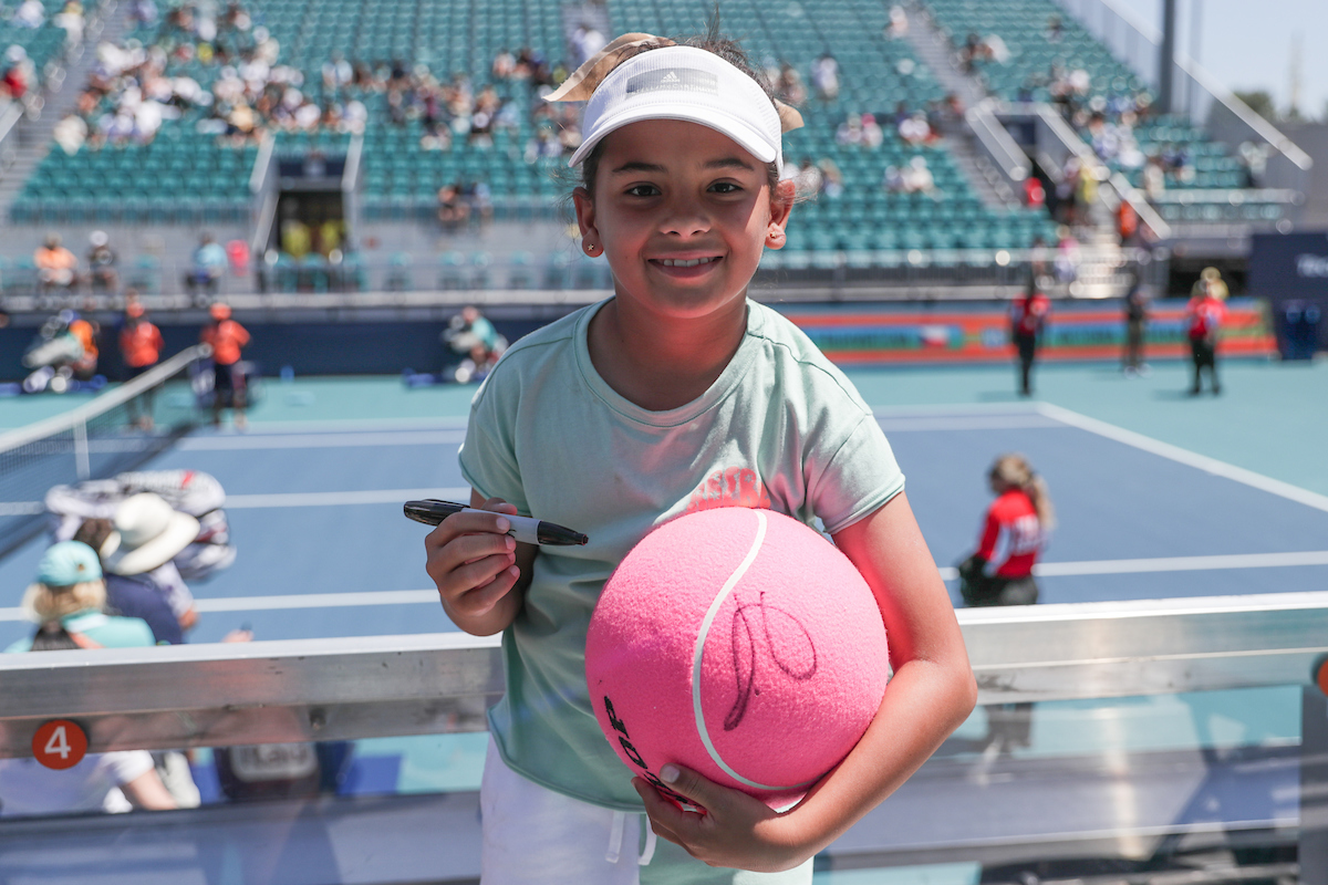 Young fan hold pink souvenir ball