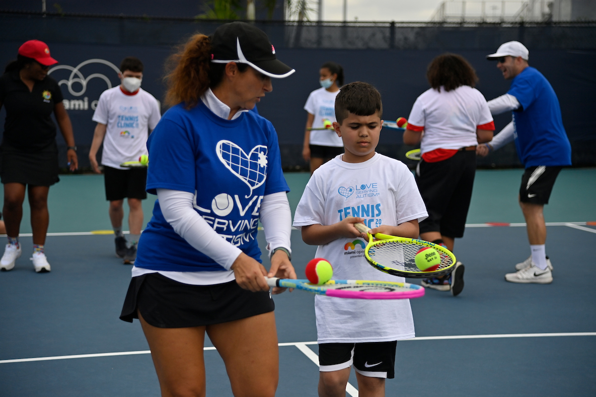 kid at Love Serving Autism tennis clinic on practice court 17-19