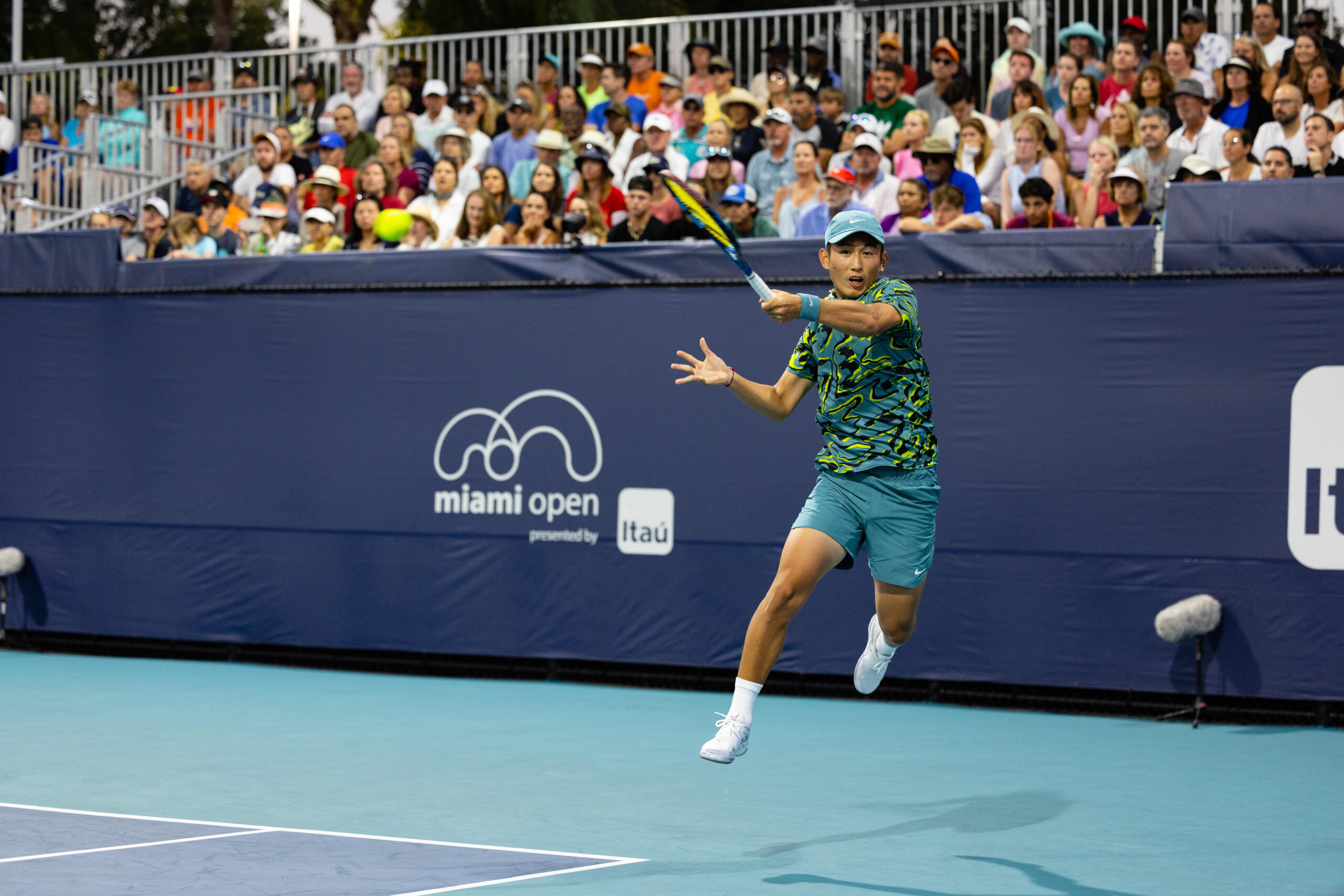 Juncheng Shang gets off the ground to hit a forehand at the 2023 Miami Open