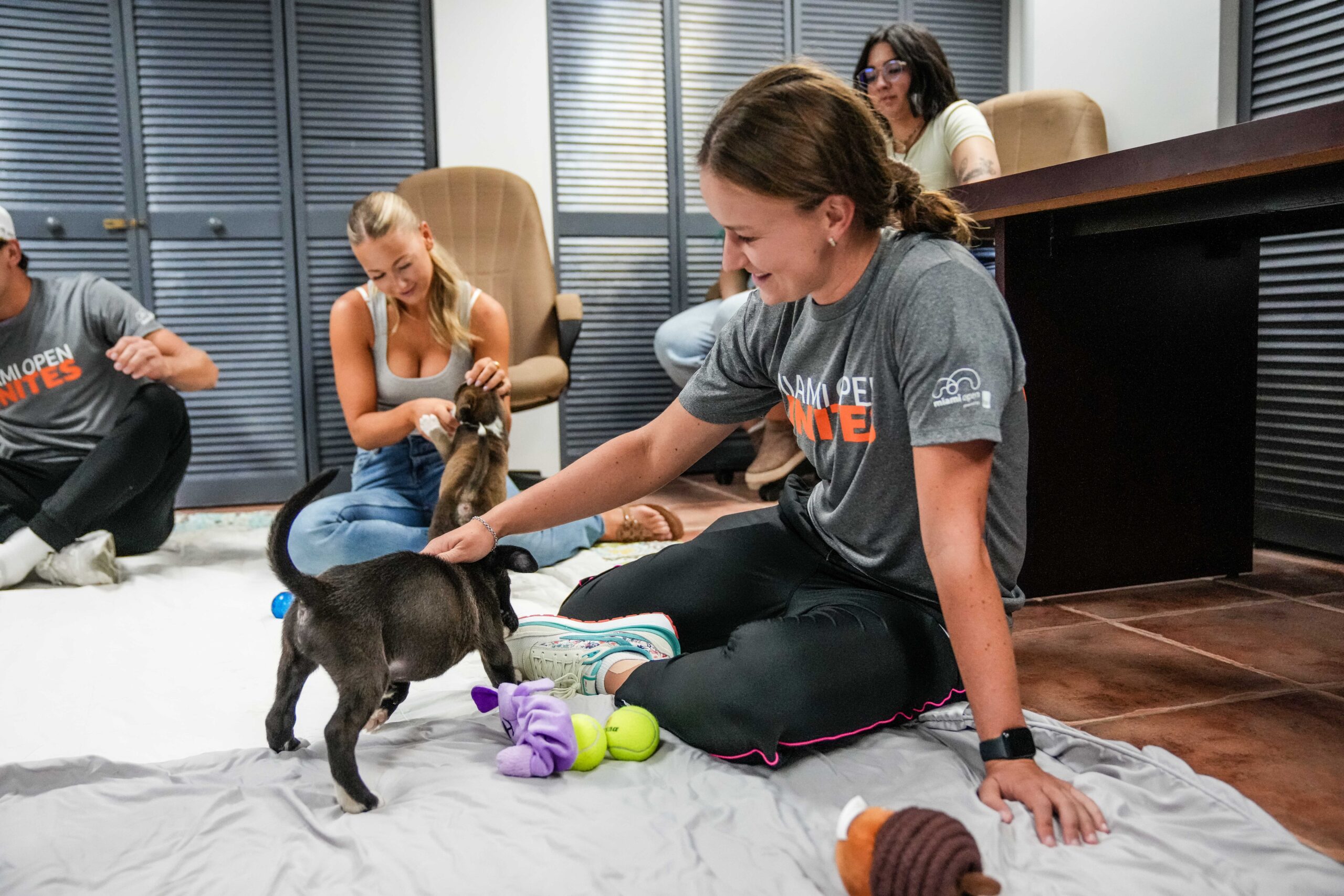 Barbora Krejcikova playing with puppy during the Miami Open Unites Humane Society event in Miami on March 20, 2023.