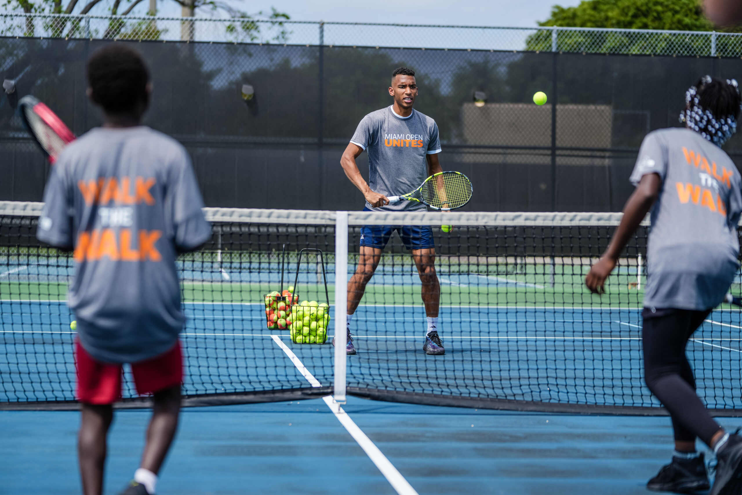 Felix Auger Aliassime on-court with participants of the tennis clinic at the Big Brothers, Big Sisters event at Moore Park in Miami on March 20, 2023.