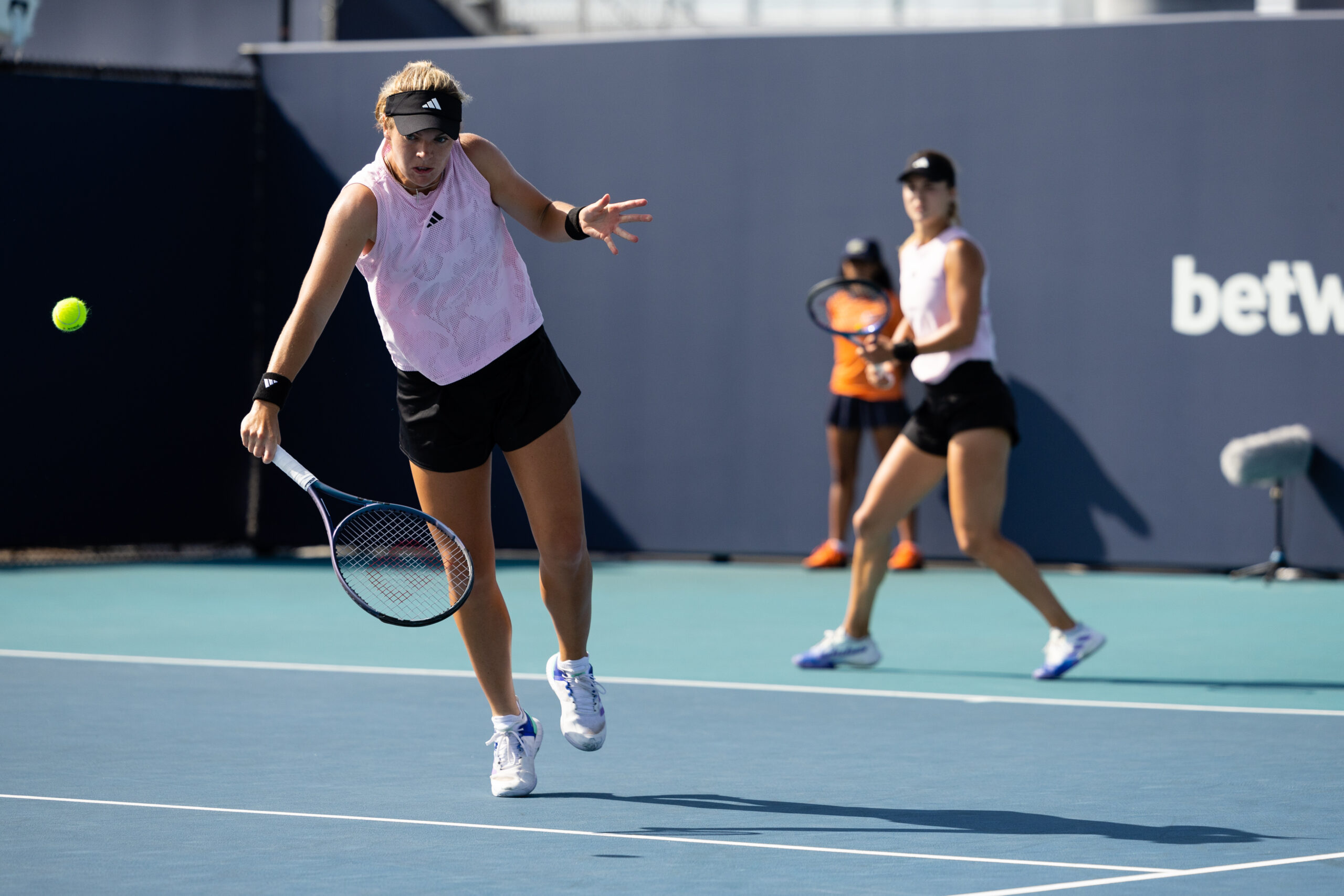 Caty NcNally volleys while partner Anna Kalinkskaya watches during the 2023 Miami Open in Miami Gardens, Florida.