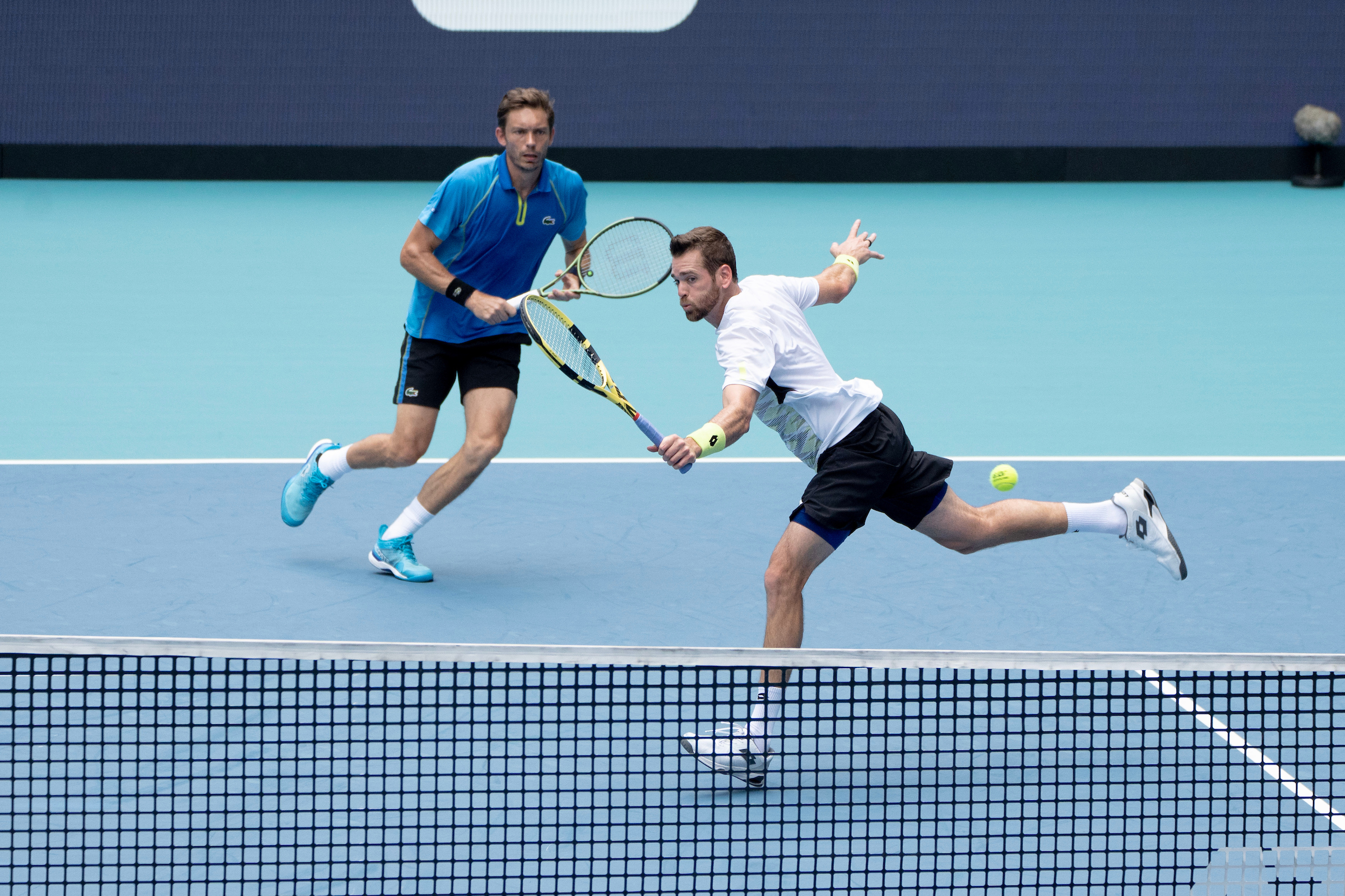 Austin Krajicek stretches for a volley as partner Nicolas Mahut looks on during the 2023 Miami Open Men's Doubles Final in Miami Gardens on April 1st, 2023.