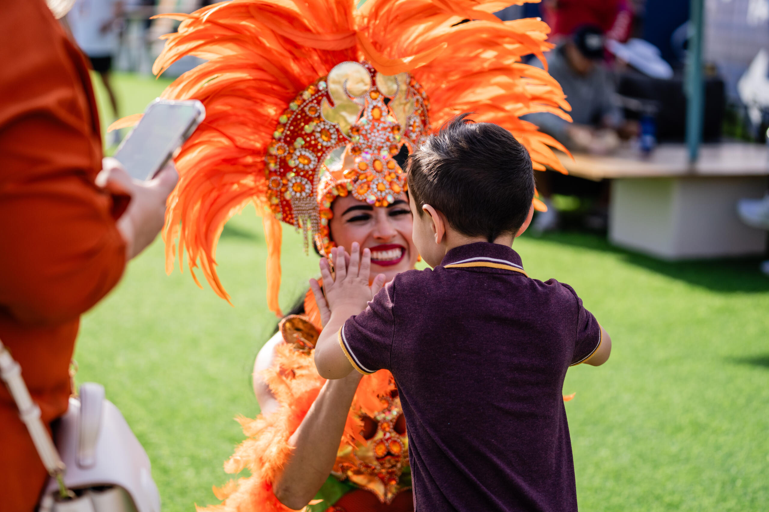 2025 Miami Open Dancer in bright orange costume high-fives a kid