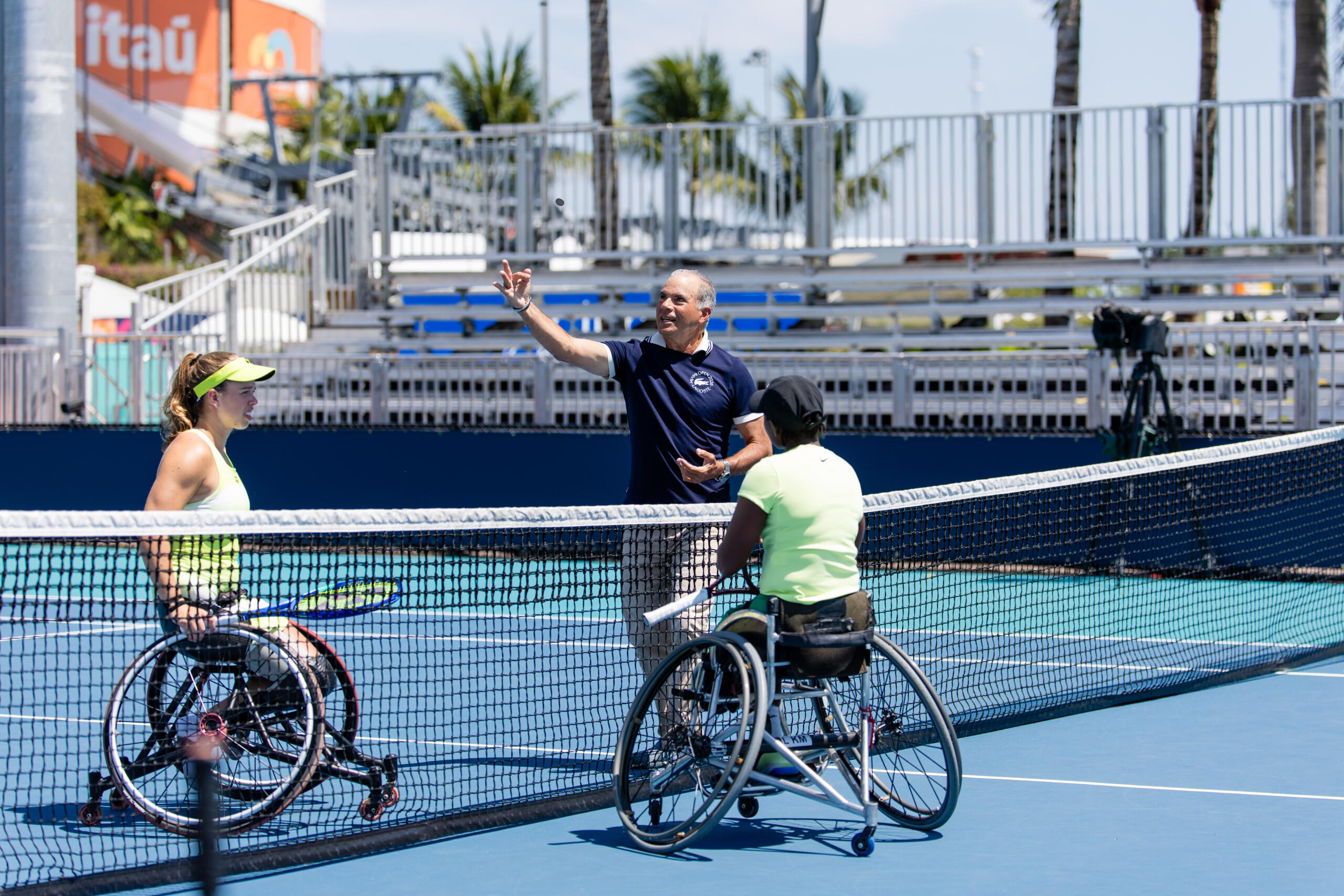 Two wheelchair tennis players meet at the net.