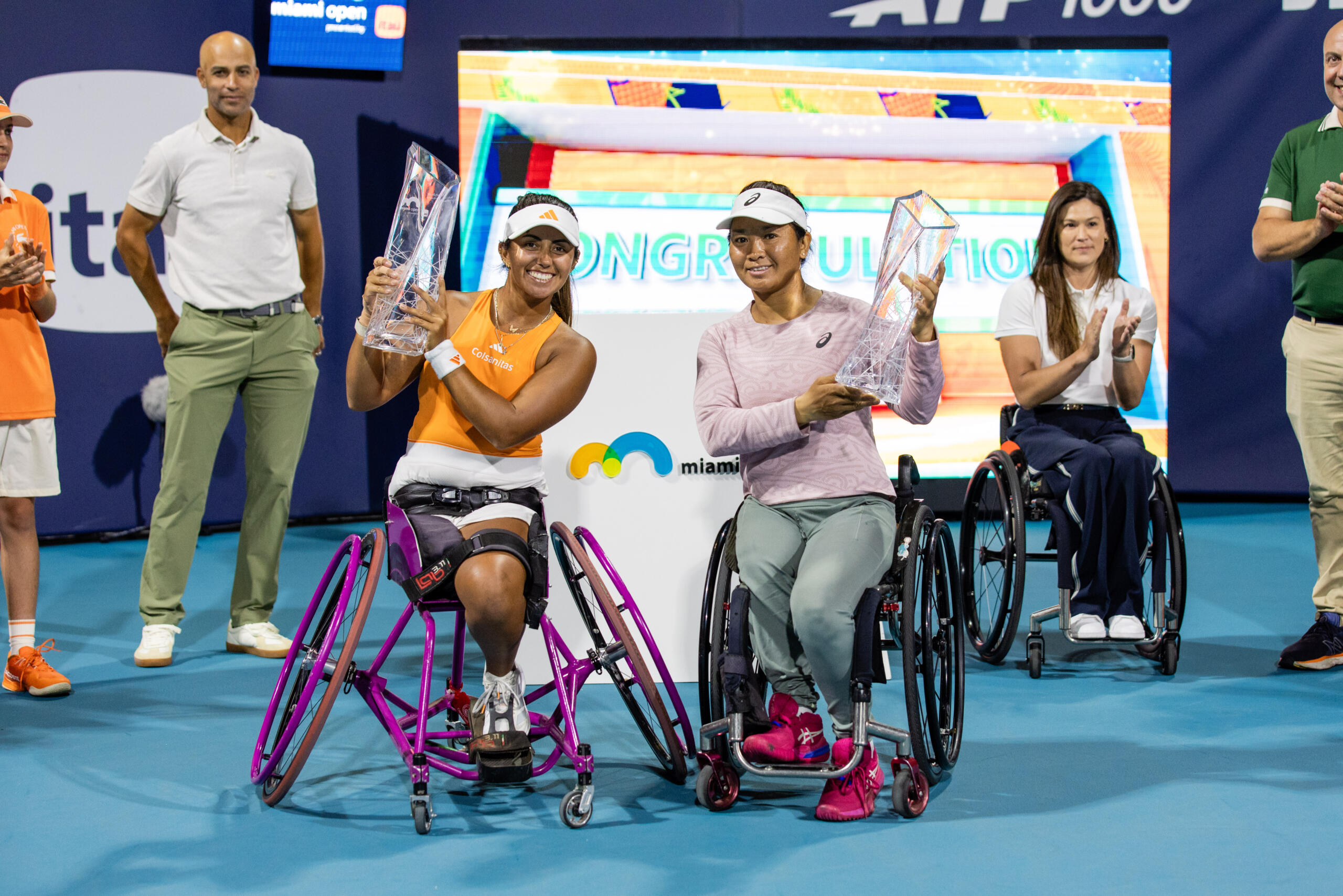 Wheelchair tennis champions hold up their trophy
