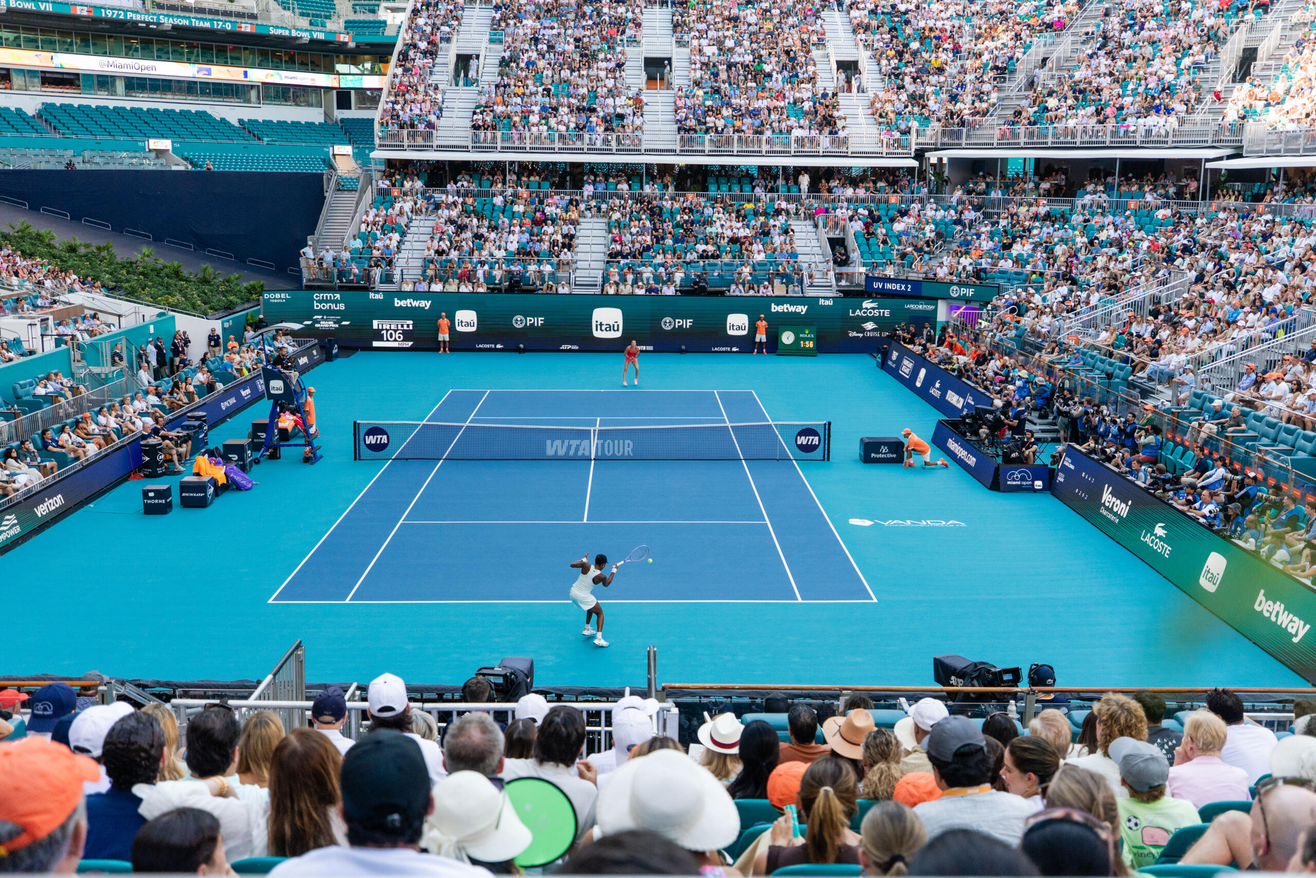 Aryna Sabalenka and Coco Gauff rally inside a packed stadium court.